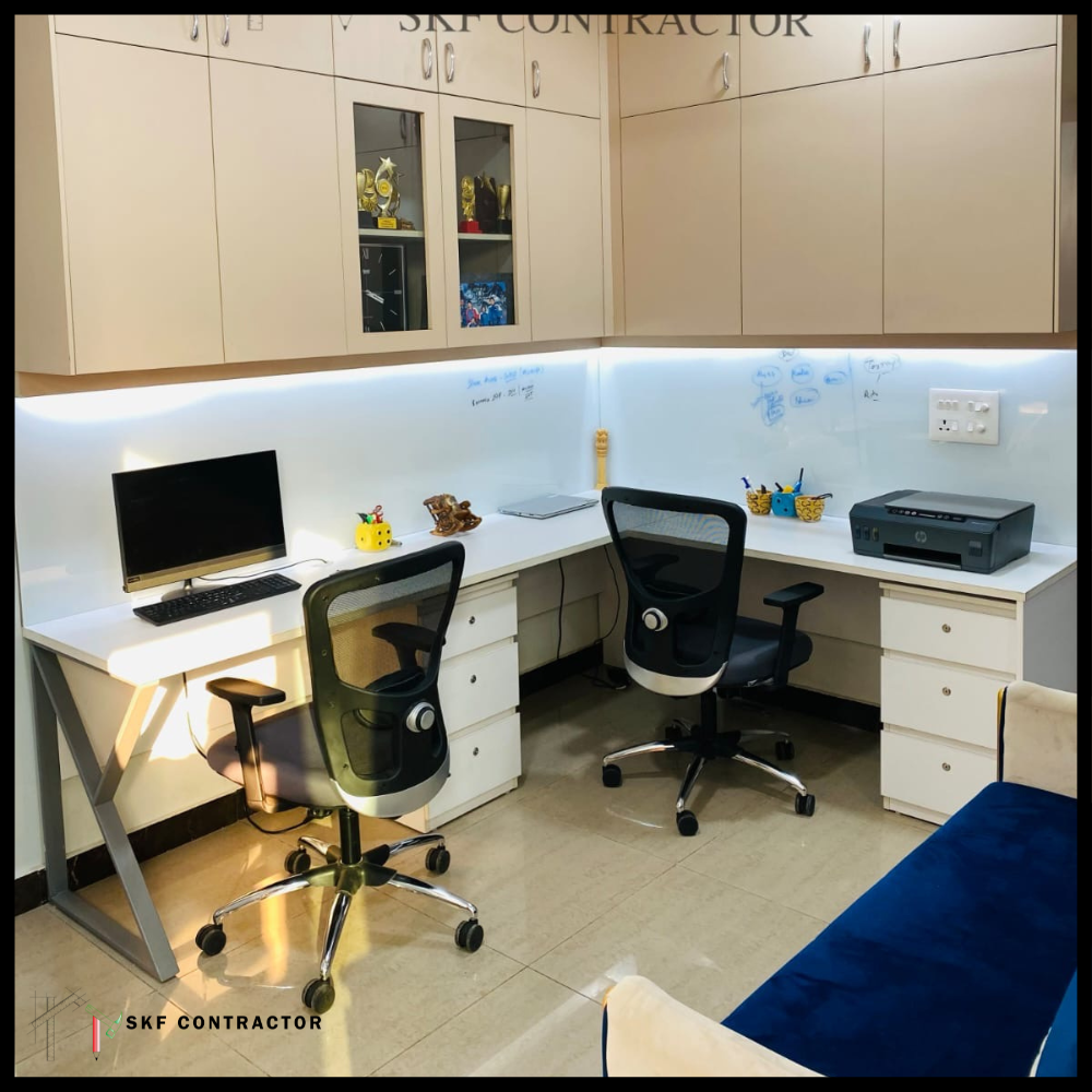 Dual L-shaped office workstation with mesh chairs, PC, printer, glass whiteboard, LED lighting, and overhead cabinets.