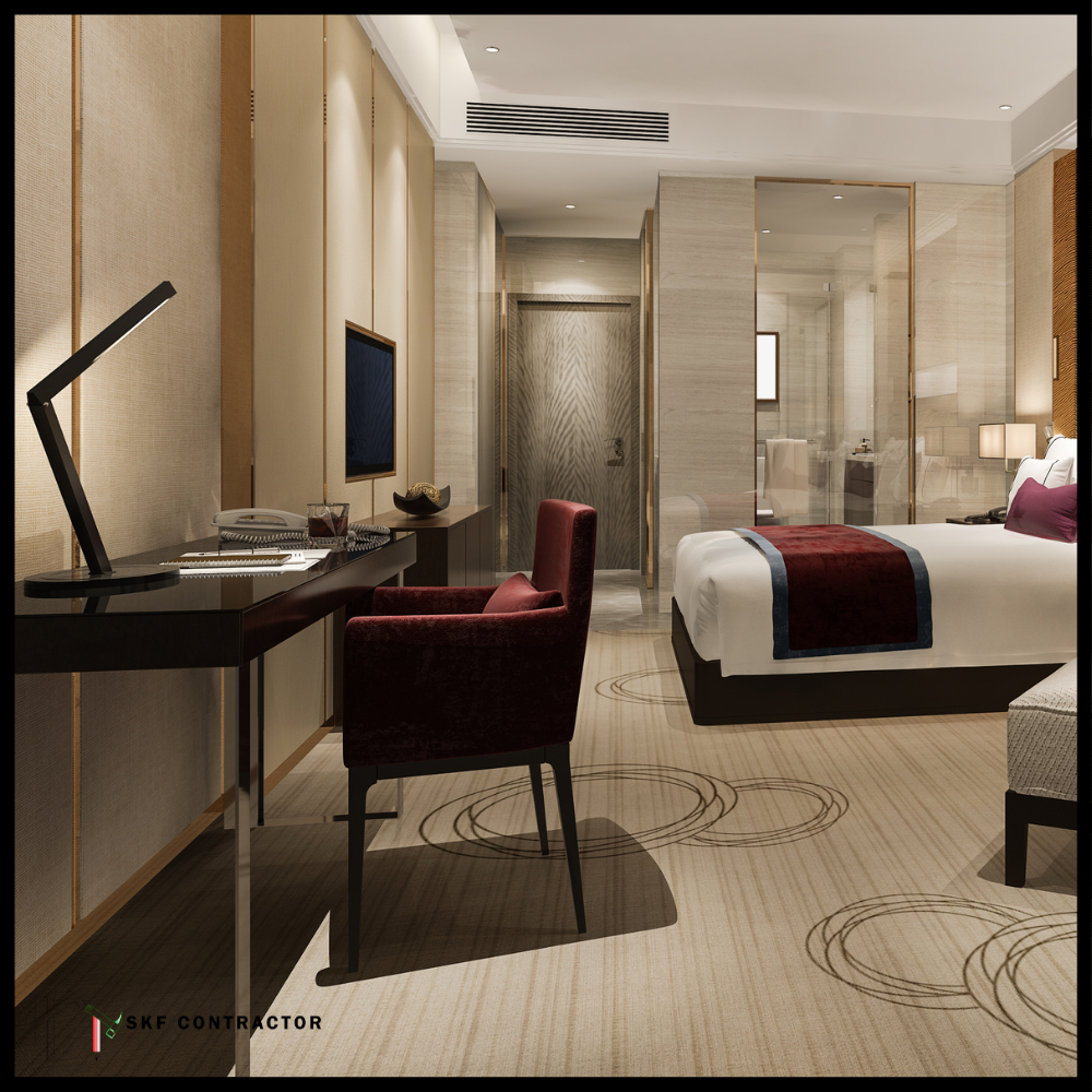 Luxury hotel suite with king bed, red velvet chair, wood desk, gold panels, and glass ensuite.